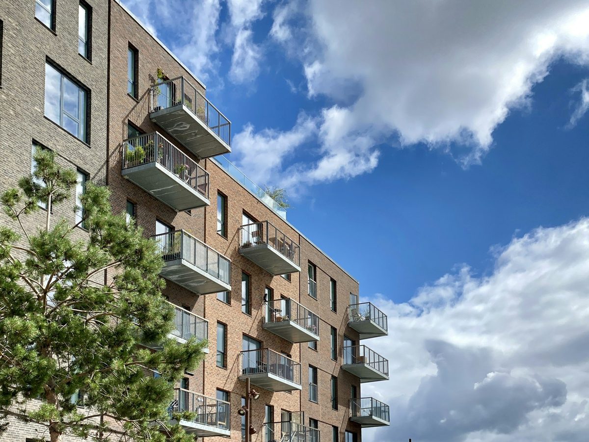 Moderne leilighetsbygg i tegl med balkonger under blå himmel